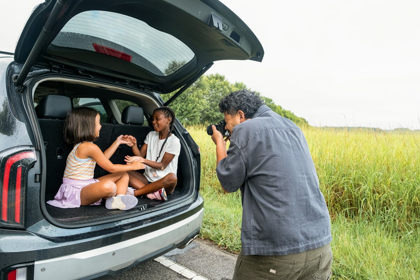 Family with kids at the car trunk